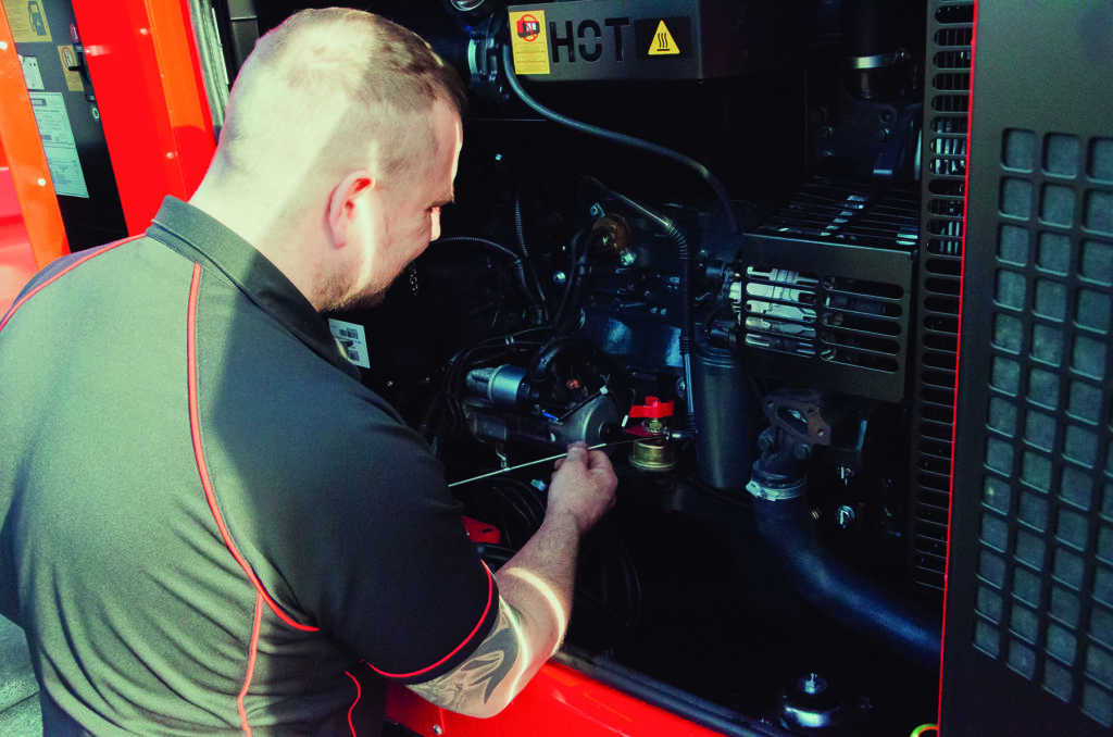 Engineer carrying out generator servicing for winter on a diesel generator ahead of storms